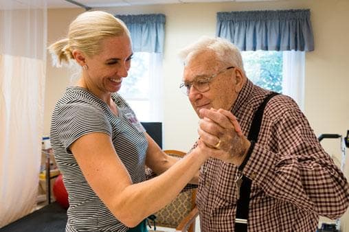 Care giver dancing with resident