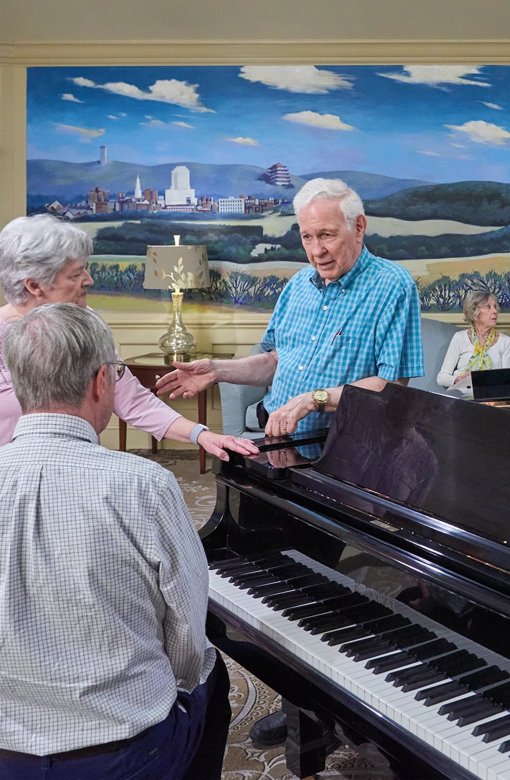 Residents engaged in conversation next to piano