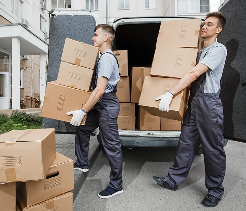 Two young men moving boxes