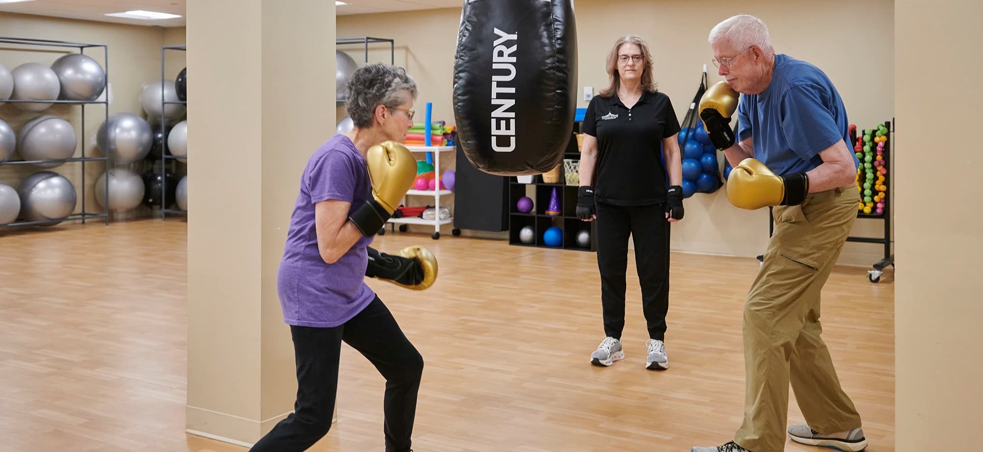 Man and woman hitting boxing bag