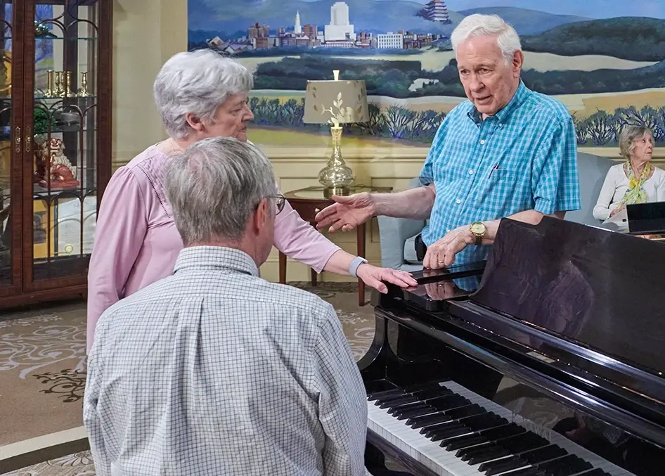 Residents in conversation next to a piano