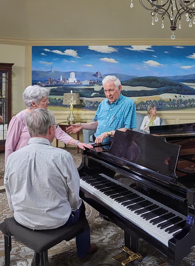 Residents in conversation next to a piano